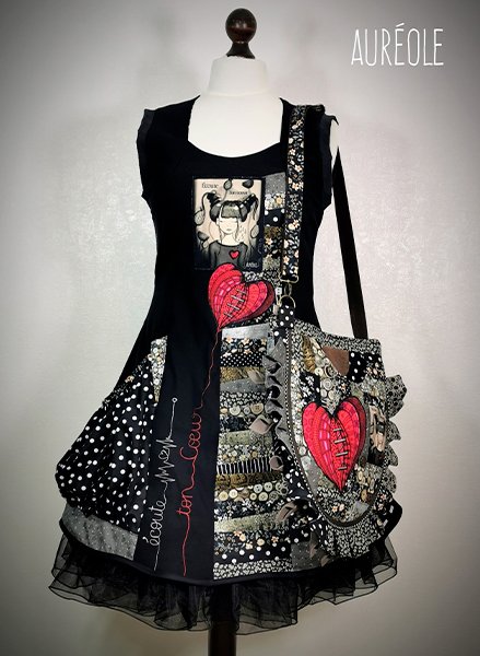 robe à poches bouffantes, noire, blanche et rouge, avec un gros coaur rouge. En broderie le texte 'ecoute ton coeur'. A l'épaule, le sac assorti.